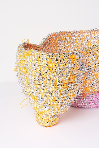 Detail of abstract coiled basket made with emergency blankets and tangerine and pink plastic lacing by José Santiago Pérez