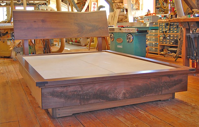 Goldyne queen-size platform storage bed.  Walnut live edge headboard with matching drawer fronts and book-matched crotch-grain footboard.  Eight drawers total.  