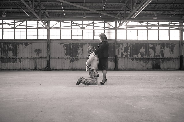 a female boss displays a tender moment with her submissive male contractor in the warehouse photographed by La Mouge Photo 
