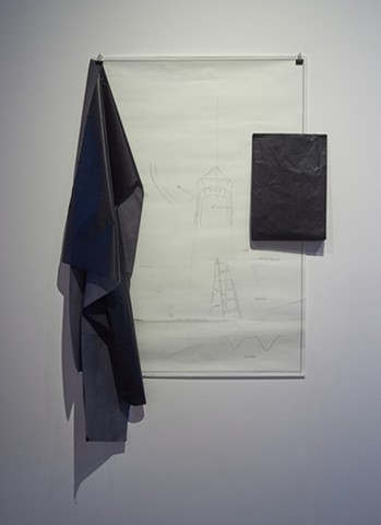 A drawing hangs by clips on the all that hold the translucent top layer against the drafting paper underneath. On the paper are fine drawings of a ladder, an arched entry way, arrows, and other abstract marks. From the top left corner of the drawing hangs