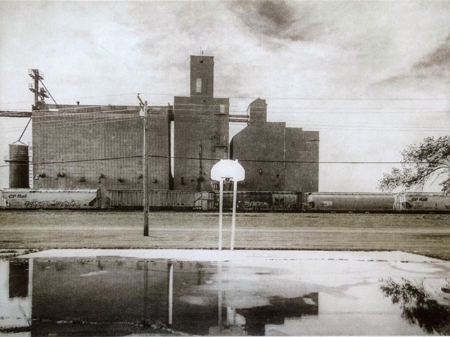 Basketball court near a railroad siding and elevator in Oslo, Minnesota. One-plate polymer photogravure print on pescia paper by John Pearson.