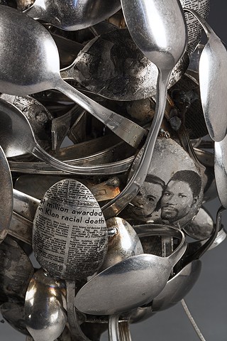 Sculpture made of metal spoons examines mixed black/white identity. Layered spoons covered with personal photos and race-related text references act of eating, feeding on or being fed information about one’s self and asks: How is identity constructed?