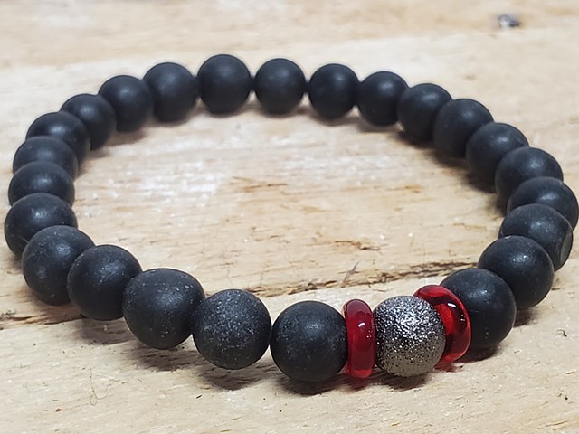 Matte Black Stone 8mm Beaded Stretch Grounding Healing Bracelet with Red Gemstone. Handmade unisex stretch bracelet for men or women made with 8mm black stone beads, with ruby red rondel and silver sparkle accent beads. Black stones offer purity, protecti
