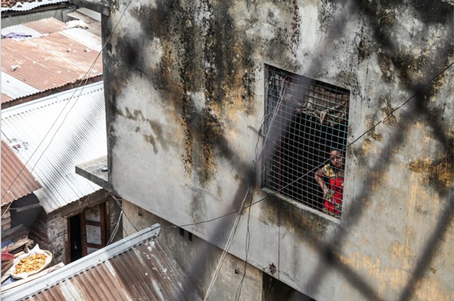 A young sex worker stares outside of a hallway window at the Rathkhola Brothel in Faridpur, Bangladesh.