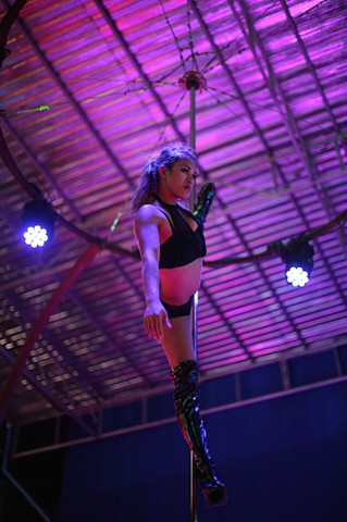 A dancer entertains tourists at an outdoor strip club in Phuket, Thailand. In contrast to Bangkok, Phuket accepts prostitution more openly because of its longstanding reputation as a resort.