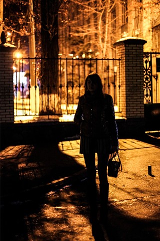 A sex worker, forced out of Donetsk by the conflict, stands in freezing temperatures along a main stretch of Kiev, Ukraine well known for prostitution. Her pimp watches her every move from a nearby building.