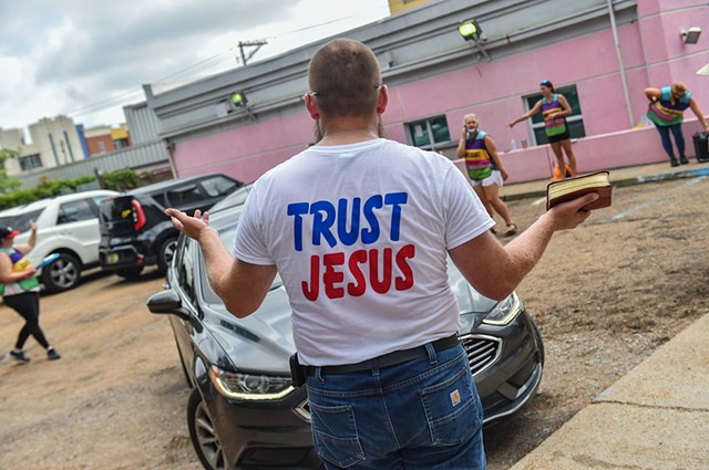 Allan Siders, an anti-abortion advocate, holds up his bible as a motorist tries to exit the Jackson Women’s Health Organization on the last day the clinic is in service in Jackson, Miss., Wednesday, July 6, 2022.