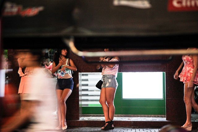 Sex workers wait on the street patiently for customers on Sukhumvit Soi 3 in Bangkok, Thailand. The street is a common attraction for American sex tourists seeking out ladyboys for the night, with hourly "love" hotels lining the streets.