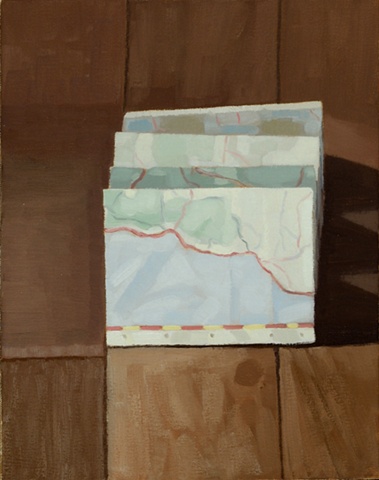 A still life painting of a folded map on a wood floor