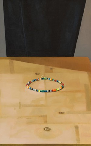 A still life painting of a string of beads on a wooden table with black cloth background