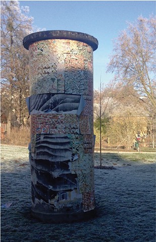 A Litfaßsäule in a park in the winter with faded and torn posters