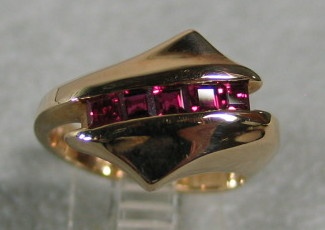 14K RING W/ CHANNEL OF RUBIES