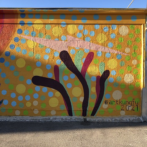Mural by Angel Quesada in Pasadena, Texas. Colorful street art evoking growth.