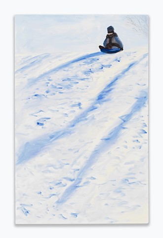 A child at the top of a hill on a sled