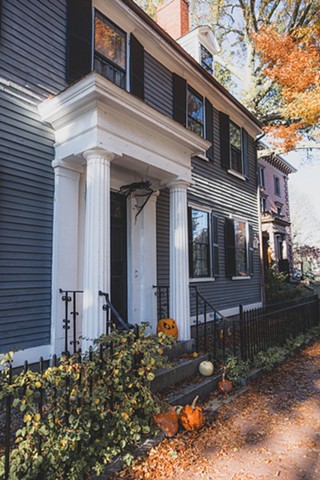 A decorated house with jack-o-lanterns and orange leaves in downtown Salem, Massachusetts
