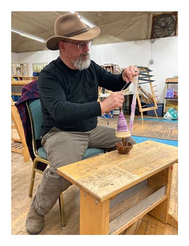 Dwayne working with a supported drop spindle