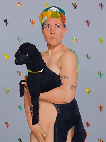 Portrait of a nude lesbian holding her dog in front of a grey cactus-pattern background.