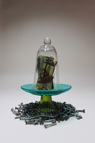 Book sculpture enclosed in bell jar.