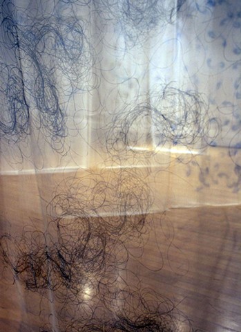 The space is filled with Screenprinted hair on silk, silk gauze creating a space of veiling,  unveiling and protecting.