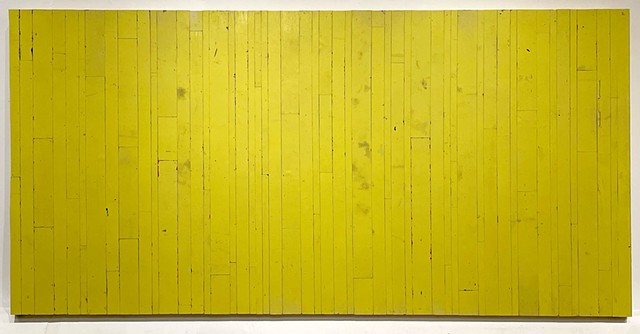 A large yellow colorfield artwork, constructed from a discarded wooden billboard