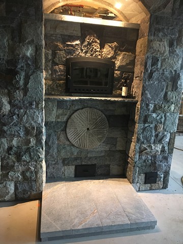 Details include a set in reclaimed mill wheel, a soapstone shelf under the oven, and a soapstone platform to reach the oven better.