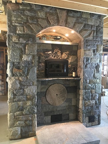 The stone columns are chimneys and the arch supports a heated bench on the second floor.
