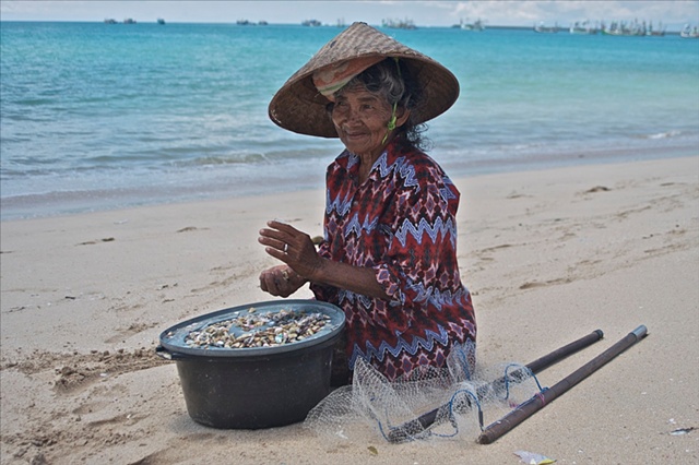 Bali Beach old woman fishing