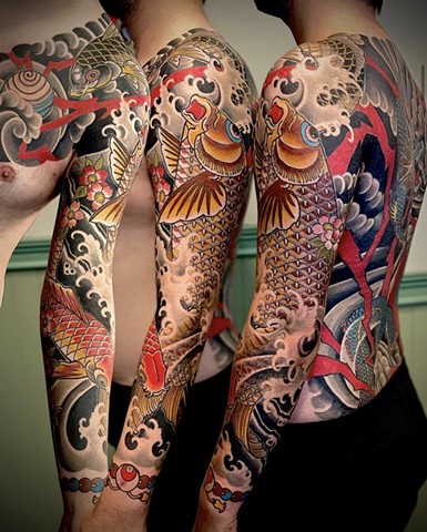 A traditional Japanese full sleeve from chest to wrist, of a giant golden koi chasing the pearl of wisdom