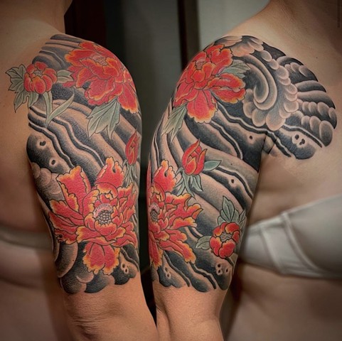 A traditional Japanese 1/2 sleeve from chest to elbow, featuring warm, red peony flowers