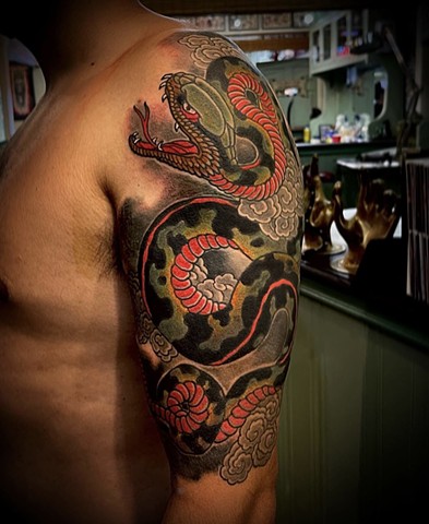 A traditional Japanese 1/2 sleeve featuring a green and red snake
