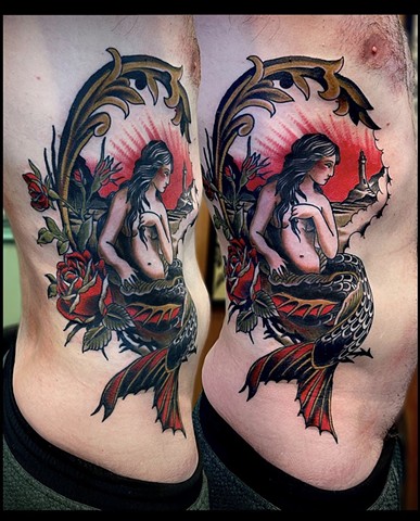 A Western Traditional style rib tattoo, featuring a mermaid and lighthouse scene, framed with red roses