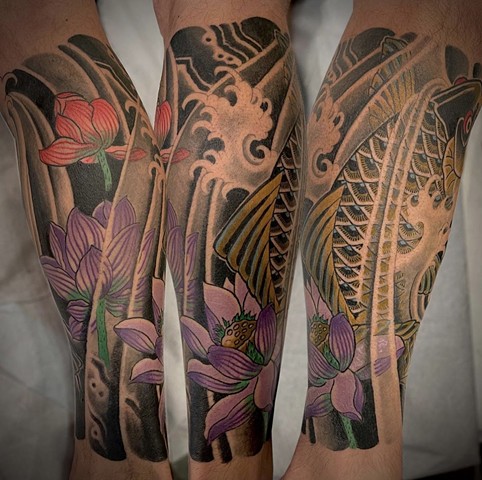 A traditional Japanese lower leg sleeve featuring a black koifish and colorful lotus flowers
