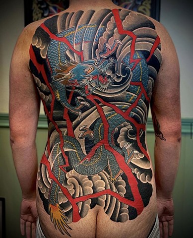 A blue traditional Japanese dragon back piece accompanied by red lightning