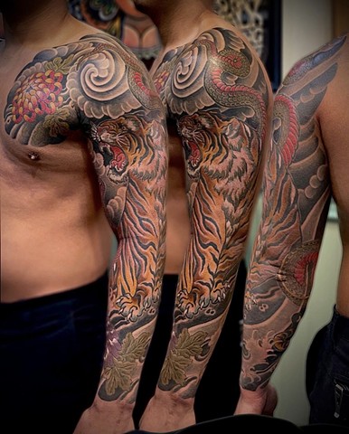 A traditional Japanese full sleeve, from chest to wrist, featuring a tiger, snake and chrysanthemums 