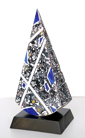 White geometric lines and cathedral blue stained glass on a gray and black background with primary color accents make this fun piece pop!  Rocks gently with just a touch of the finger.  On a black wooden painted base.