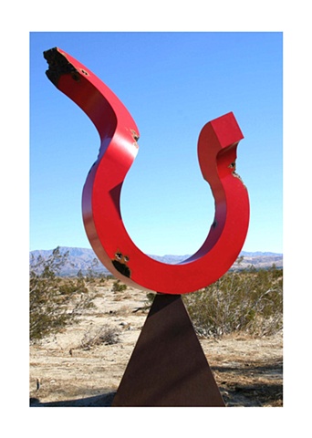 Large painted red outdoor steel sculpture with fractures and patina on steel base.