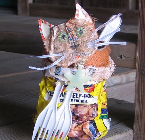 Recycled ordinary materials are assembled into a folk art cat basket