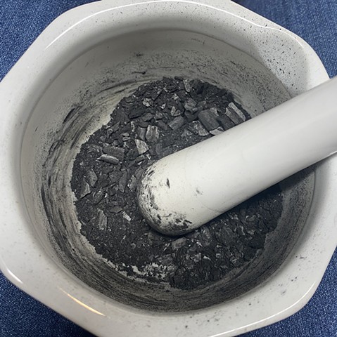 Grinding charcoal into a powder for ink and dyeing paper