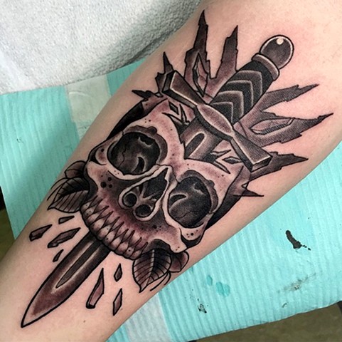 Detailed skull and dagger tattoo, black and grey traditional style on the arm. Made in Toronto
