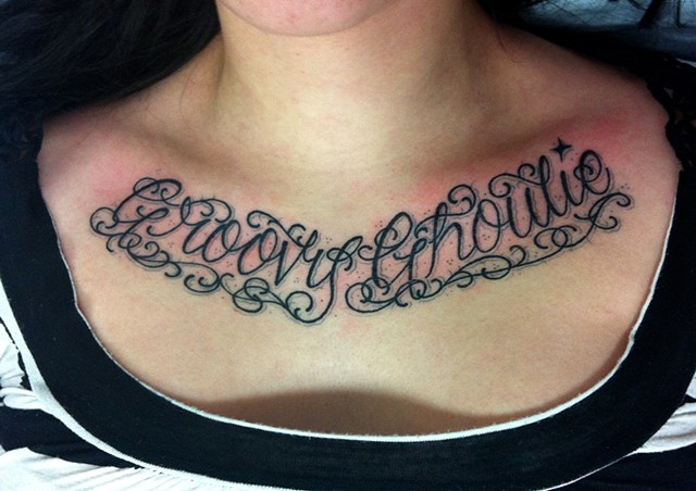 Fancy decorative script letterin tattoo on chest, made in Toronto