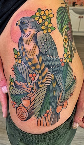Nature bird tattoo of a peregrine falcon in flowers and branch in a traditional or neo-traditional style with bold style and colour