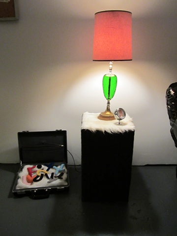 Luv Letters and Brief case next to fur table, lamp and portrait