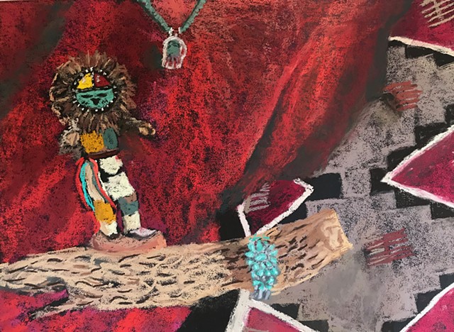 A still life with a kachina doll, Navajo rug, turquoise bracelet, and a piece of cactus wood