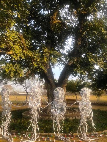 Mother Earth's Tinfoil Tribe displayed under an old banyan tree