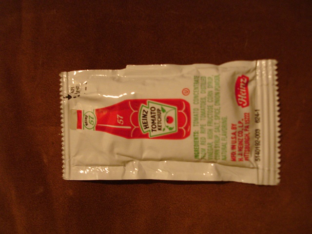 a packet of heinz ketchup that the artist opened emptied of its contents refilled with tomato seeds then sealed . its looks are like its never been touched.