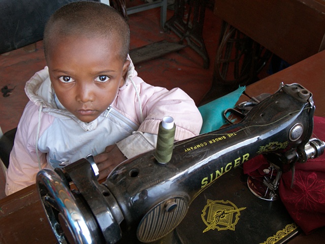 Child with sewing machine