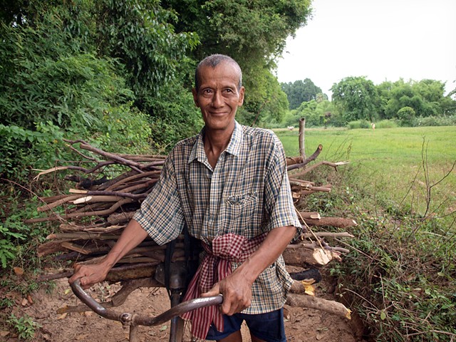 Villager pushing bicycle loaded with wood