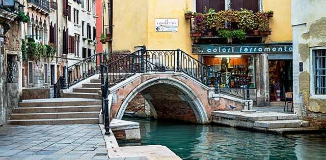Yellow stucco by turquoise waters of a Venice Canal