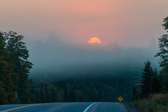 Big Red Sun rising over the hills in Algonquin Park Ontario