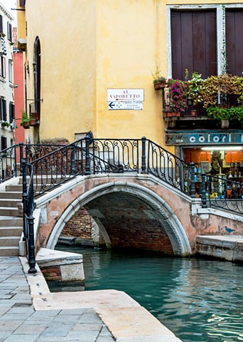 Vertical Version bridge over turquoise waters of a Venice canal,